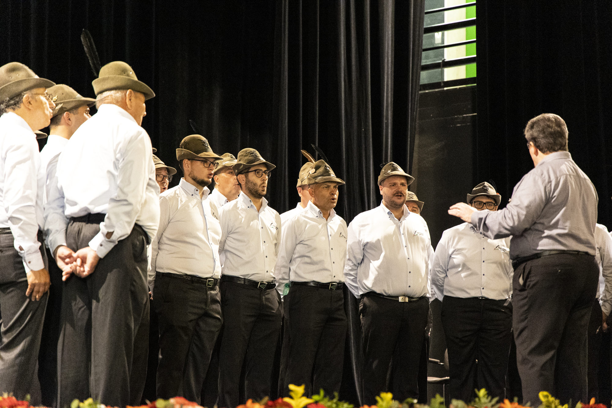 Die Sänger des Coro A.N.A. Latina mit Alpini-Hut auf der Bühne